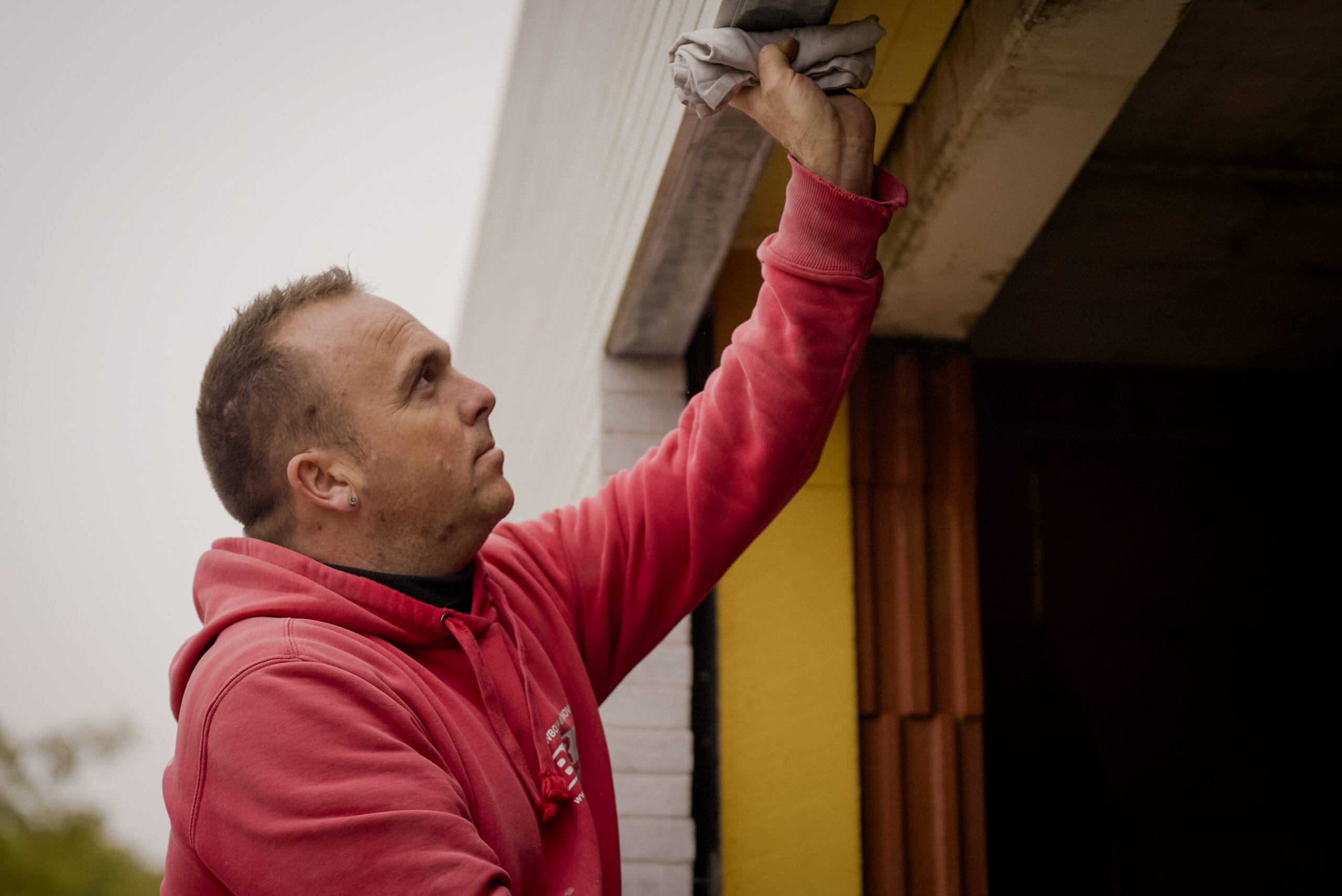 Gevelsteen verlijming MaxPro vakman op de werf